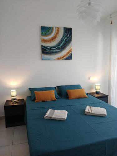 a blue bed with two towels on top of it at la mer la corse in San-Nicolao