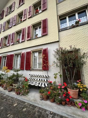 a building with flowers and a bench in front of it at Little Flowerpot in Unterseen