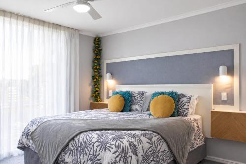 a bedroom with a large bed with yellow pillows at Sea Breeze Apartment in Mandurah