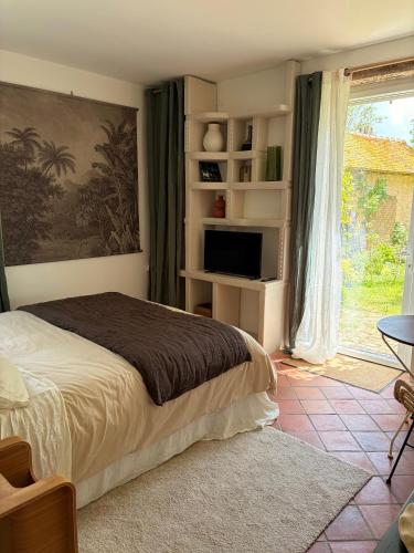 a bedroom with a bed and a large window at Clos Lujatis in Valençay