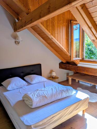a bed in a room with a wooden ceiling at Gîte FRAIZE in Fraize