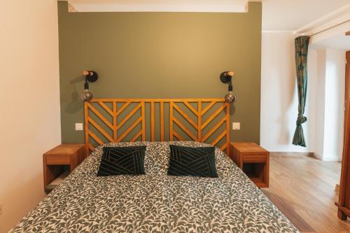a bedroom with a bed with a wooden headboard at Chez Gabriel et Sophie in Pérouges