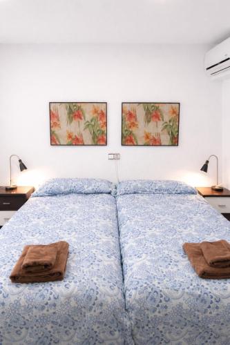 a bedroom with a bed with two pictures on the wall at Alojamiento San Juan en Murcia Centro in Murcia