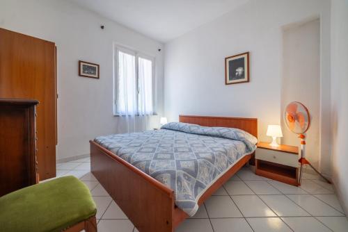 a bedroom with a bed and a green chair at Acqua e Sale in Pomonte