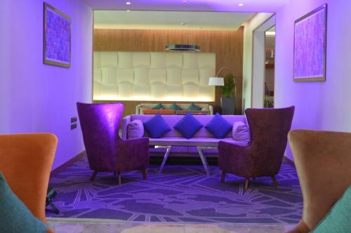 a purple living room with a purple couch and two chairs at Novotel Yanbu Albahr in Yanbu