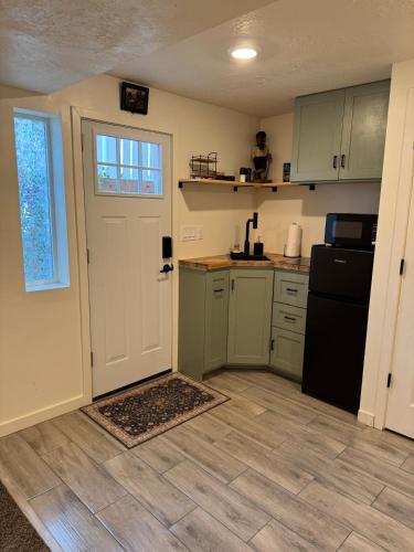 a kitchen with a white door and a black refrigerator at Green Clover Hideaway in Draper