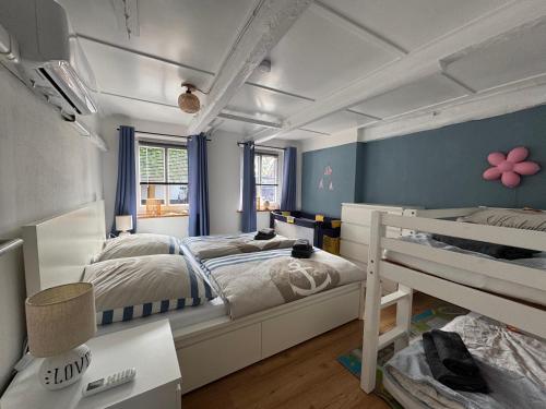 a bedroom with two bunk beds and blue walls at Dat Lütte Huus - Ferienhaus nahe Greetsiel in Krummhörn