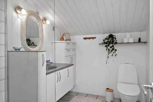 a white bathroom with a toilet and a mirror at 329-Thisted-Sandtornvej-21 in Thisted