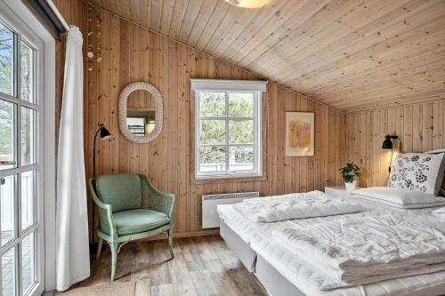 a bedroom with a bed and a chair and a window at 329-Thisted-Sandtornvej-21 in Thisted