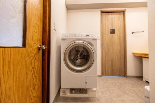 a washer and dryer in a room with a door at Lax奈良Annex in Mitsugarasuchō