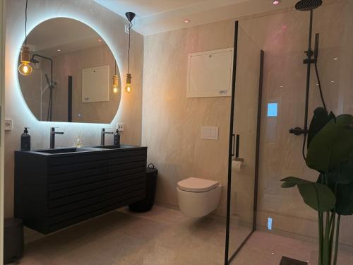 a bathroom with a sink and a toilet and a mirror at Villa Nyheim in Florø