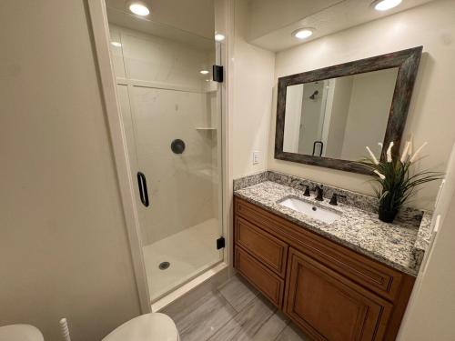 a bathroom with a sink and a shower with a mirror at Green Clover Hideaway in Draper