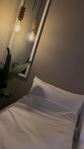 a bedroom with a white bed and a mirror at Villa Nyheim in Florø