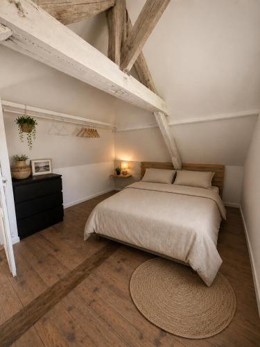 a bedroom with a large bed and a rug at Maison Plumeria in Triel-sur-Seine