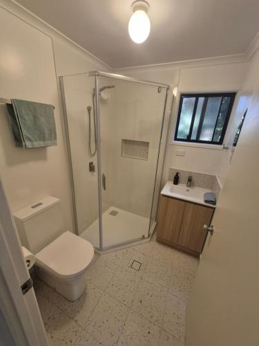 a bathroom with a shower and a toilet and a sink at Rainbow Heights 2 Bed Apartment in Rainbow Beach