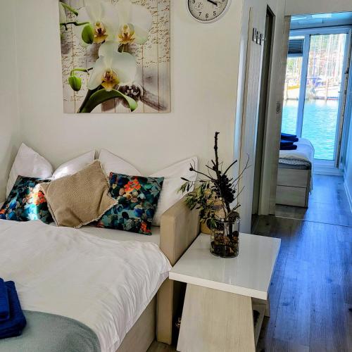a bedroom with a bed and a table and a clock at MIRAMARE Romantic Experience with privat Jacuzzi - floating house in Portorož