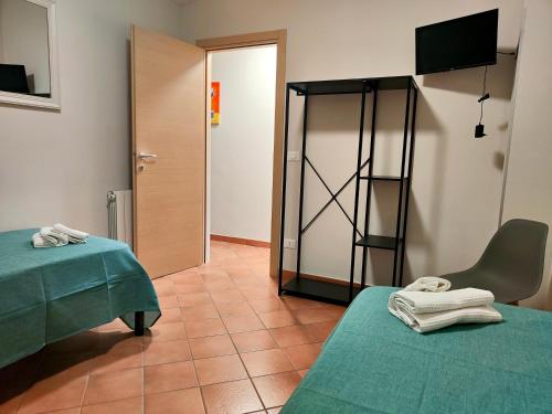 a room with two beds and a chair and a door at La Casa di Stefy - affittacamere in Cammarata