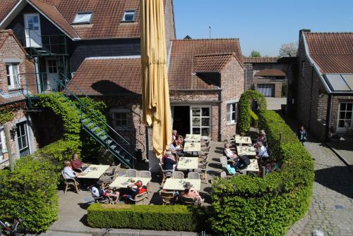 a group of people sitting at tables outside a building at De Sjeiven Dorpel in Maaseik