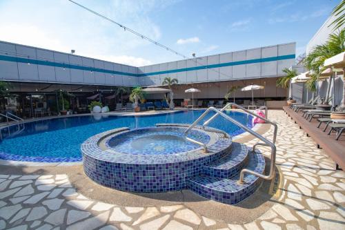 a large swimming pool with a spa in the middle at Changi Transit Hotel Terminal 1 in Singapore