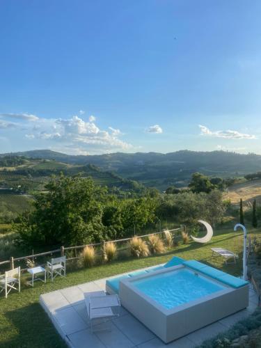 a swimming pool with two chairs and a table at Poderino - a place to feel in Cento