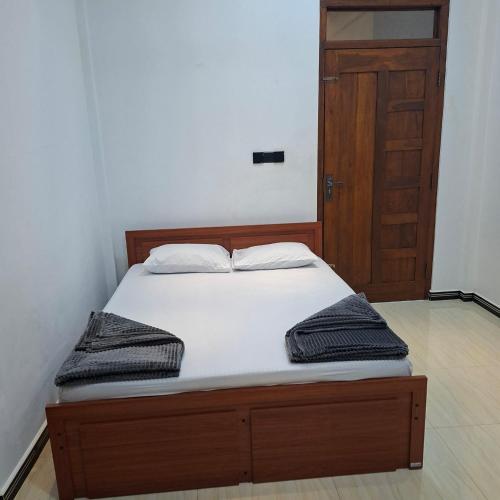a bed with two pillows on it in a bedroom at Trinco Harbour Villa in Trincomalee