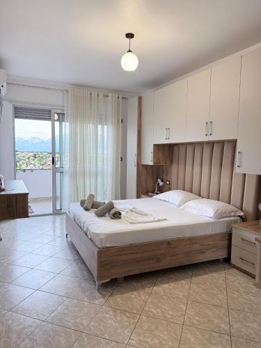 a bedroom with a large bed and a large window at Jacuzzi Central Apartment in Shkodër