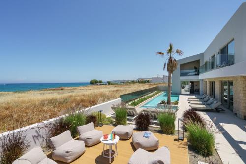 a villa with a view of the beach at New Beachfront Mesogaia Villa with Heated Pool, Jacuzzi & Playroom, 60m from the beach in Pigianos Kampos