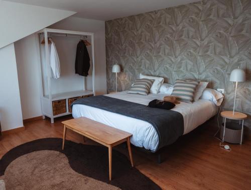 a bedroom with a large bed and a table at La Marisol Ribeira in Ribeira