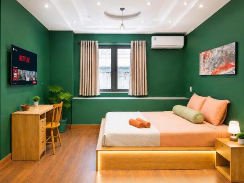 a green bedroom with a bed and a desk at Ben Thanh Hideaway - A Cozi Stay in Ho Chi Minh City