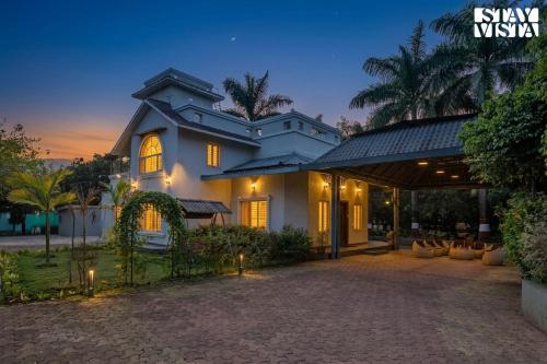 a villa with a driveway in front of a house at Hindavi Green Escape by VEO - Part of StayVista with Bonfire, BBQ & Pool in Pune