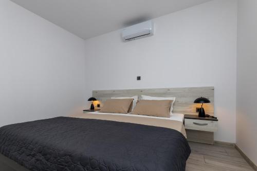 a bedroom with a large bed and two lamps at Apartman Klara in Vrgorac