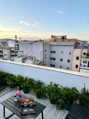 a balcony with a table and a view of a city at KK Athens Fine Stay -Neos Kosmos-Modern Apartments Opposite Metro with Rooftop Lounge & Acropolis Views in Athens