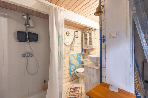 a bathroom with a shower and a toilet in it at Petite Maison Typique in La Cotinière