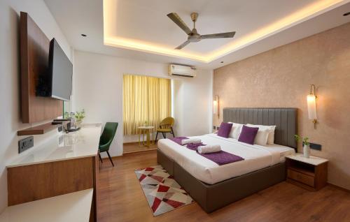 a hotel room with a large bed and a desk at North Centre in Cochin