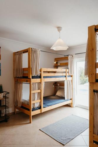 a bedroom with bunk beds in a room at Aldeia Caiçara Surf Lodge - Arrifana in Aljezur