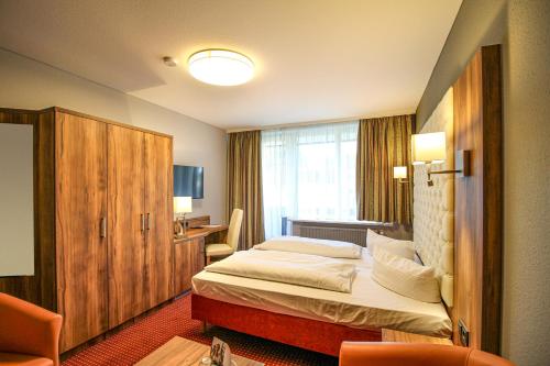 a hotel room with a bed and a desk at Morada Hotel Bad Wörishofen in Bad Wörishofen