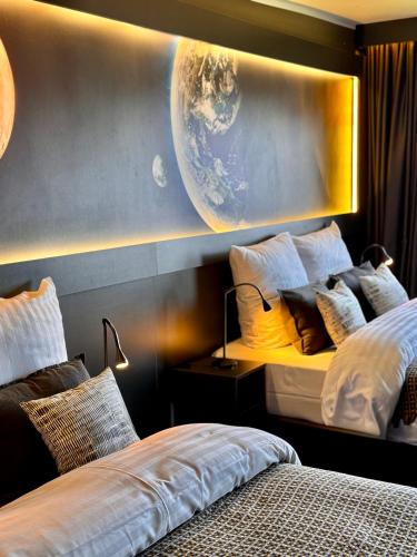two beds in a room with a planet on the wall at Sleephotels Cosmos in Hamburg