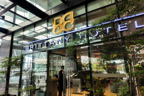 a man standing in front of a store front at Brittany Hotel BGC in Manila