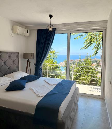 a bedroom with a bed and a large window at Molla Apartments in Ulcinj