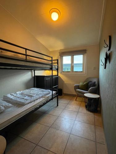 a bedroom with two bunk beds and a couch at Cozy Chalet in Berkhout