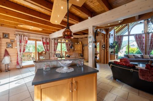 a kitchen and living room in a log cabin at Chalet Du Pont Des Fées in Gérardmer