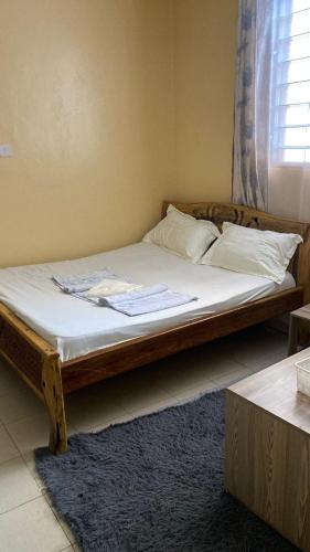 a bed with white sheets and pillows in a room at Margin Diani in Ukunda