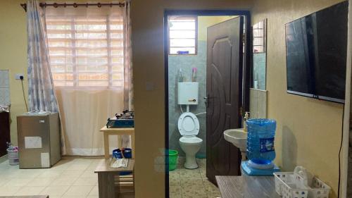 a bathroom with a toilet and a television in it at Margin Diani in Ukunda