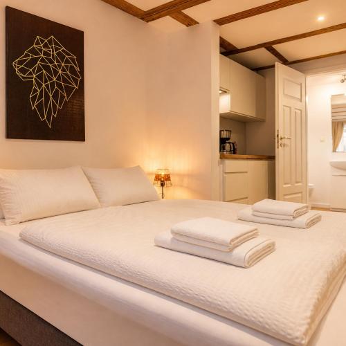 a white bed with two towels on top of it at Wismar Apartments - Cozy and Central in Wismar
