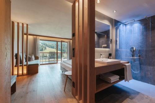 a bathroom with a sink and a shower and a mirror at Brunelle Seiser Alm Lodge in Alpe di Siusi