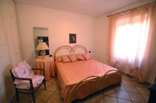 リオ・マリーナにあるLe Maree Susannaのベッドルーム1室(ベッド1台、椅子、窓付)