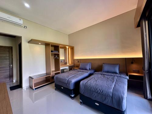a bedroom with two beds in a room at Puri Bali Hotel in Lovina
