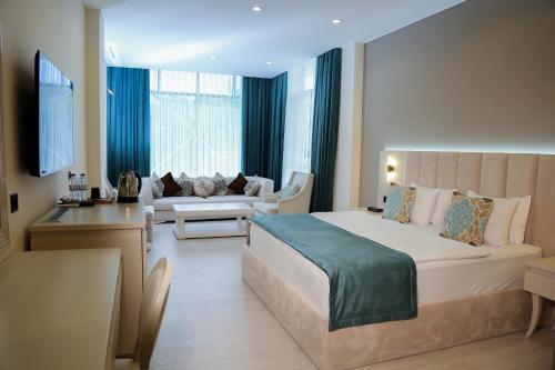 a bedroom with a large bed and a living room at Chukhur Gabala Museum Hotel in Gabala