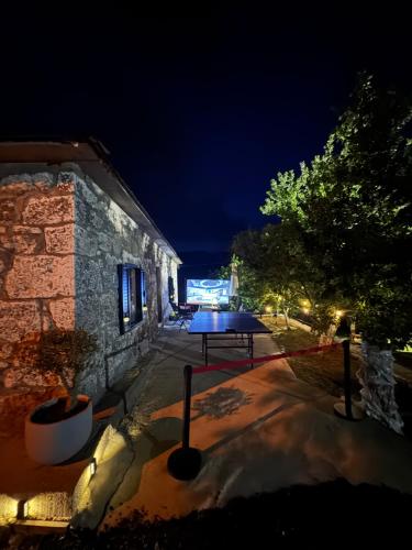 a building with a table in a yard at night at LOPATE mountain stone house in Lopate