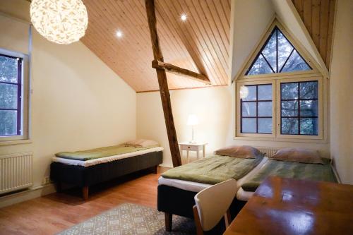 a bedroom with two beds and a table in a room at Kivimäen Matkailutila in Masku